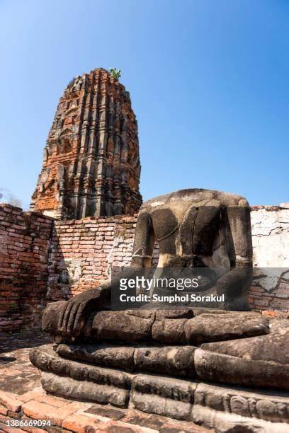 One of the ruined Buddha statues by the central principle Prang at Wat Mahathat, Ayuthaya, Thailand - Stock-Fotografie